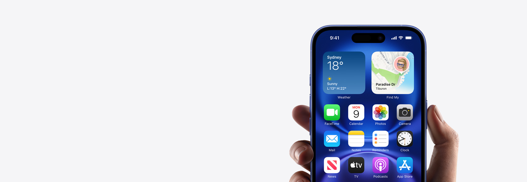 Hand holding iPhone 16 with screen showing Home Screen photo, icons and widgets.