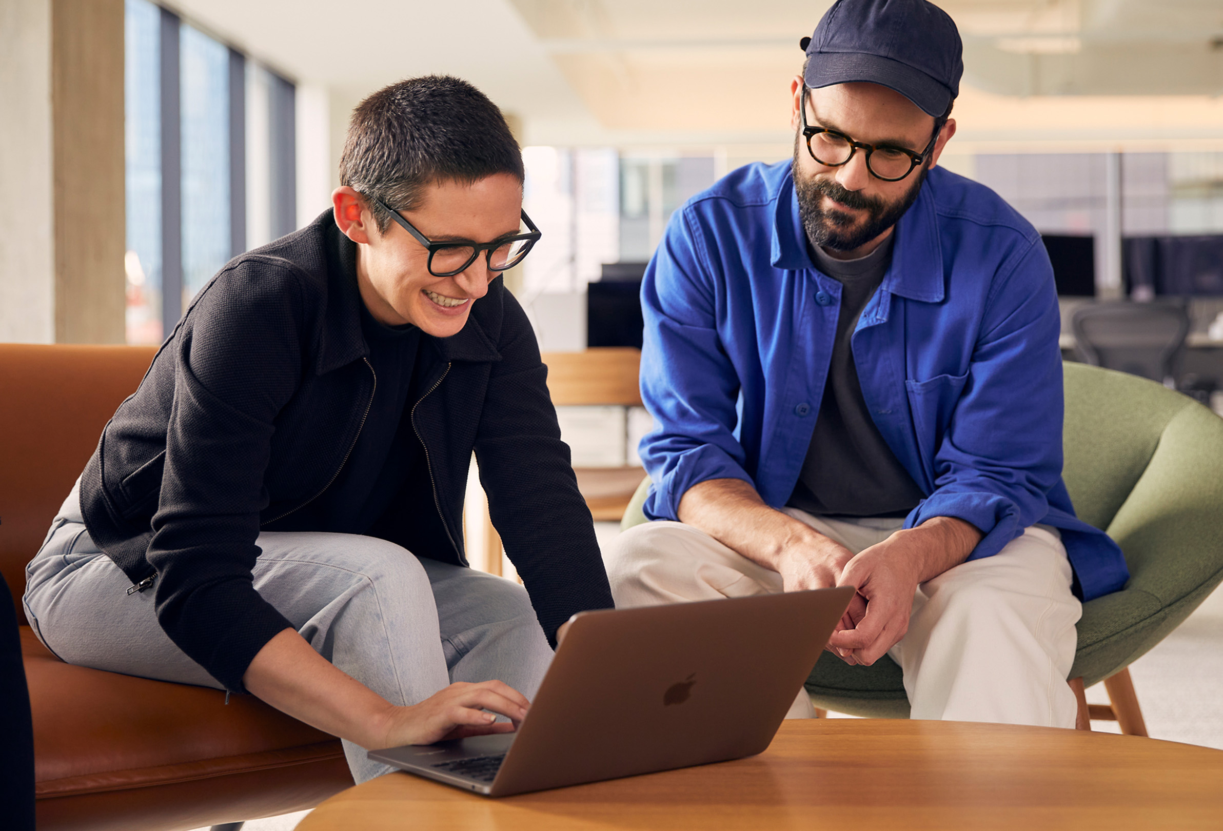 两位 Apple 员工使用 MacBook 共同协作。