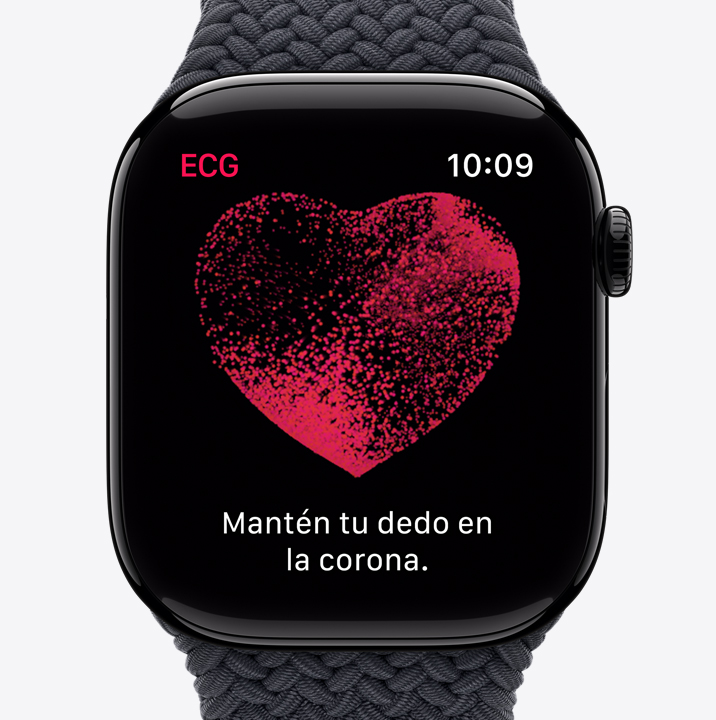 En la pantalla de un Apple Watch Series 10 aparece la app ECG. La imagen muestra un corazón rojo con partículas que se mueven en su interior. El texto dice “Mantén tu dedo en la corona”.