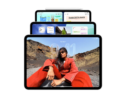 Tre modelli di iPad in orizzontale, uno dietro l’altro, una Apple Pencil agganciata magneticamente al lato superiore del modello più in fondo, l'iPad frontale mostra la schermata di blocco con effetto Liquid Glass, quello centrale mostra la Schermata home con alcuni widget. L’iPad più in fondo mostra due app affiancate, come esempio di allineamento delle finestre