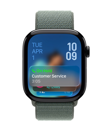 Apple Watch in Jet Black with Sage strap, Face shows Hold assist notification at bottom, date on top left, time numerals stacked at top right