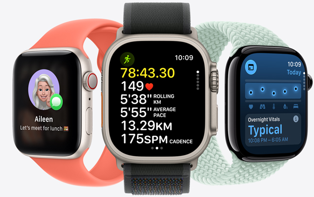Three Apple Watch models, centre in Natural colour with Black strap, face shows run in progress with heart rate stats; right in Jet Black with Aquamarine strap, face shows Vitals; left in Starlight with Tangerine strap, face with Genmoji