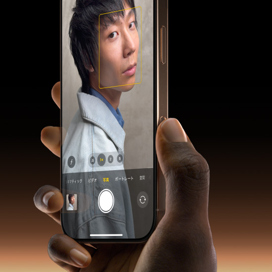 デザートチタニウムのiPhone 16 Proを手で持っている。親指でカメラコントロールボタンをスライドし、写真の機能を選んでいる