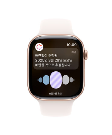 화이트 스포츠 밴드를 장착한 Apple Watch Series 10 전면의 UI에 배란일, 생리 주기 기록이 표시되어 있습니다.
