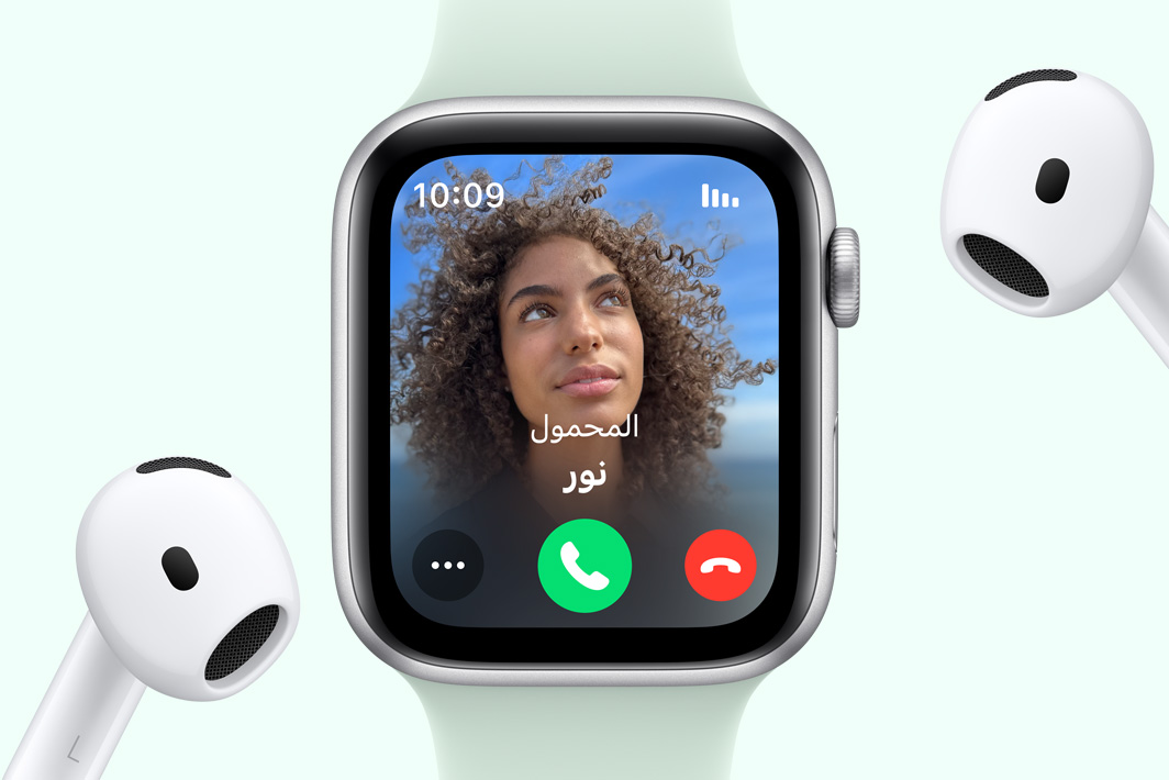 Apple Watch SE تعرض مكالمة واردة بجانب زوج من سماعات AirPods