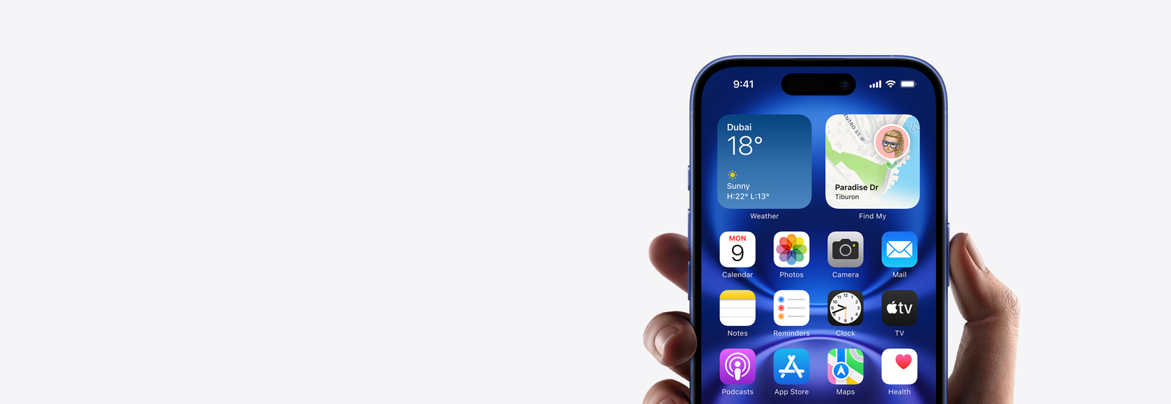 Hand holding iPhone 16 with screen showing Home screen photo, icons, and widgets.