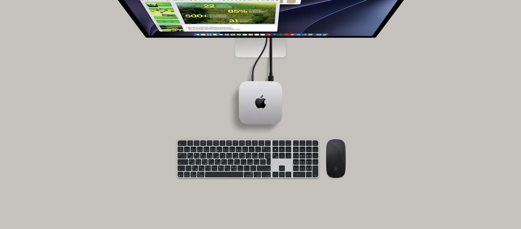 جهاز Mac mini، الجهة العلوية، ألومنيوم فضي، زوايا مدورة، شعار Apple باللون الأسود اللامع في الوسط، متصل بسلك، شاشة Studio&nbsp;Display تظهر بشكل جزئي في الأعلى، سماعات AirPods&nbsp;4، مفتوحة، عينات ألوان Pantone، ولوحة مفاتيح وماوس من Logitech باللون الأحمر