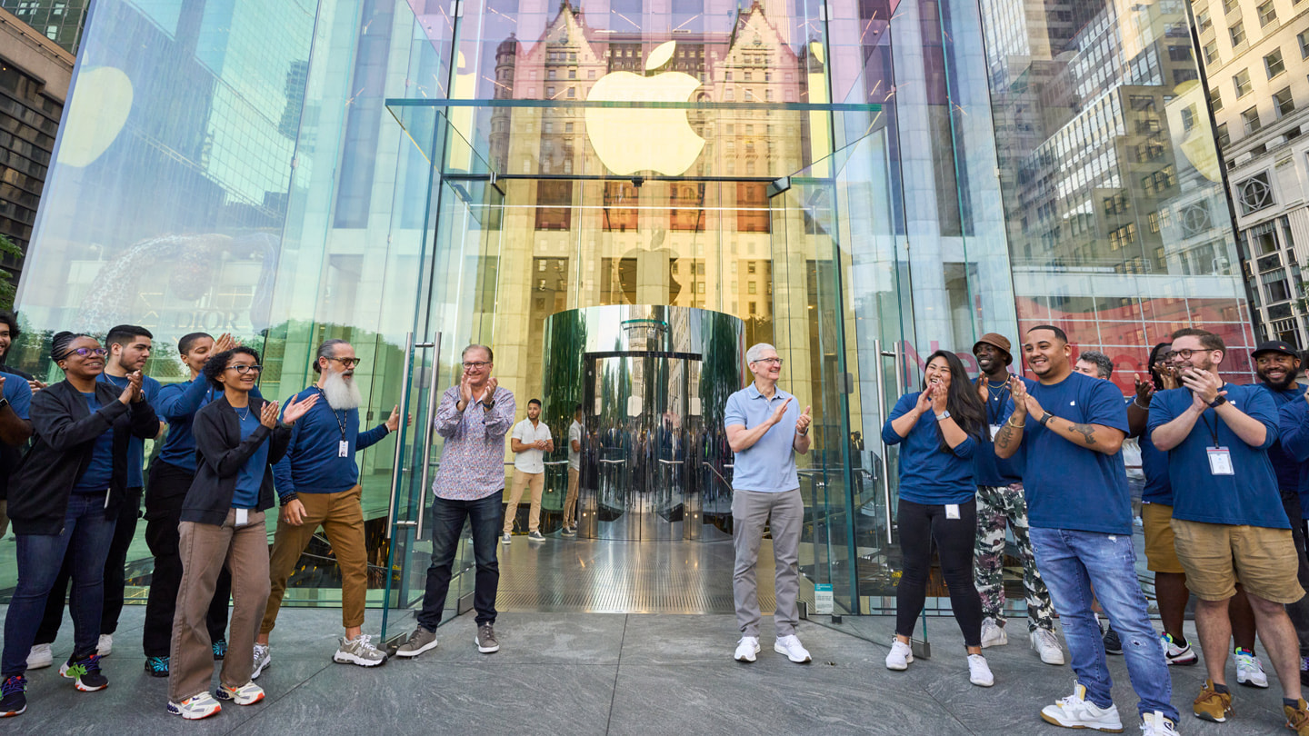 Greg Joswiak a Tim Cook vítají zákazníky v prodejně.