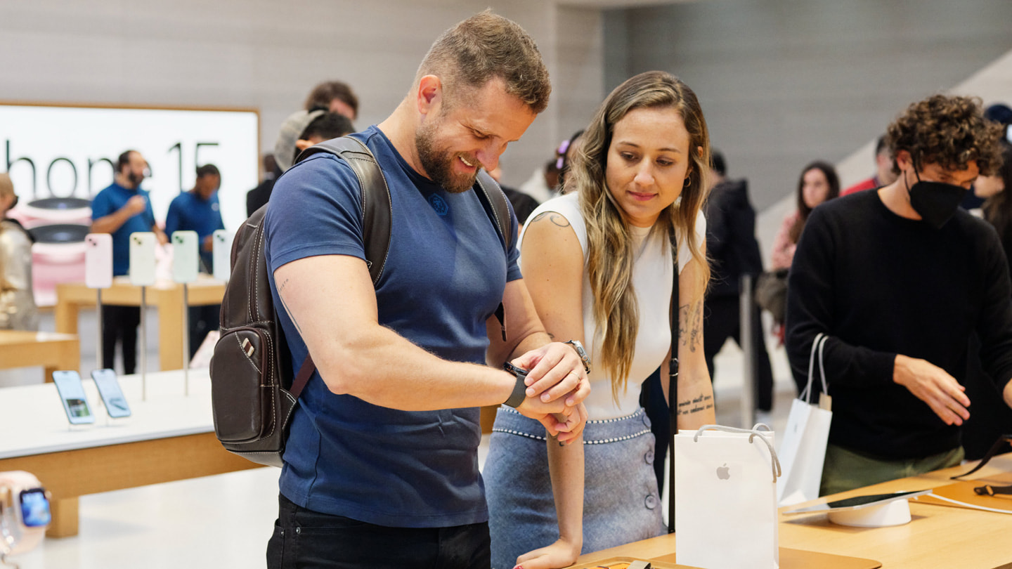 Dva zákazníci si prohlížejí nejnovější modely hodinek Apple Watch v newyorské prodejně na Fifth Avenue. Zákazník vlevo si zkouší hodinky Apple Watch Series 9.