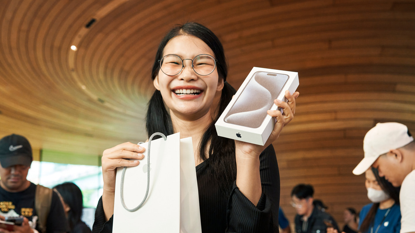 Zákazník se chlubí svým novým iPhonem 15 Pro Max v bangkocké prodejně Central World.