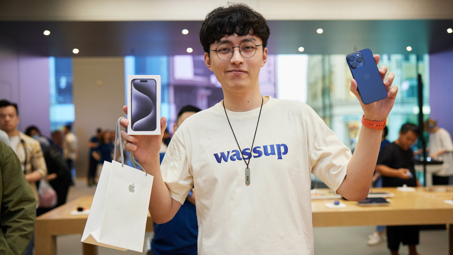 Mladý zákazník se chlubí svým novým iPhonem 15 Pro Max v modré barvě.