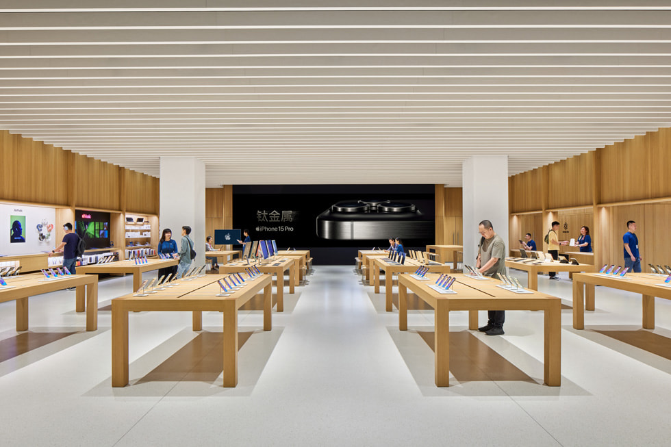 Các nhân viên nói chuyện với khách hàng bên trong Apple MixC Ôn Châu.