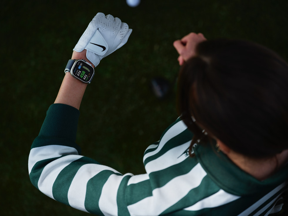 Hình ảnh golf thủ đang xem Apple Watch chụp từ trên xuống. 