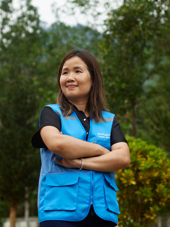 Foto van Chu Thanh Hoa, die buiten poseert in een blauw Gravity Water-hesje.