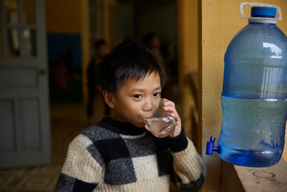 Een leerling drinkt water dat afkomstig is van het Gravity Water-systeem op de kostschool voor basis- en middelbaar onderwijs voor etnische minderheden in Vay Nua.