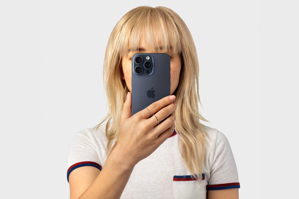 Hình ảnh một người cầm iPhone 15 Pro trước mặt.