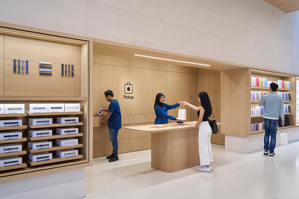 Twee medewerkers helpen een klant bij het gedeelte voor ophalen in Apple The Exchange TRX.