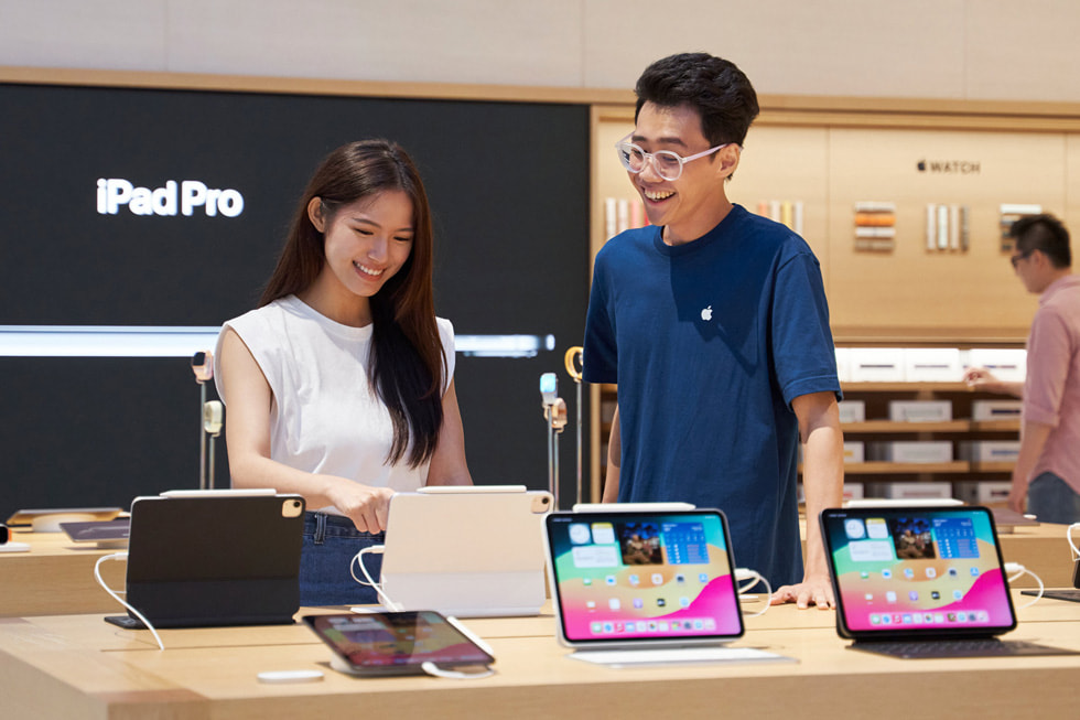 Een klant en een medewerker staan bij de iPad-opstelling in de Store.