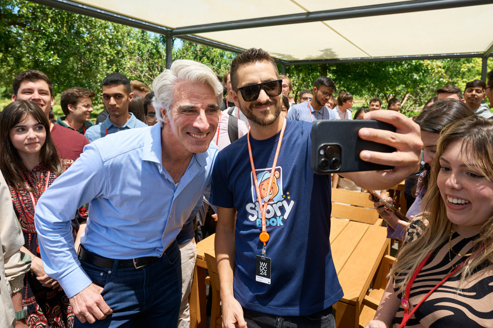 Craig Federighi tạo dáng chụp ảnh selfie xung quanh là các nhà phát triển tại Apple Park. 