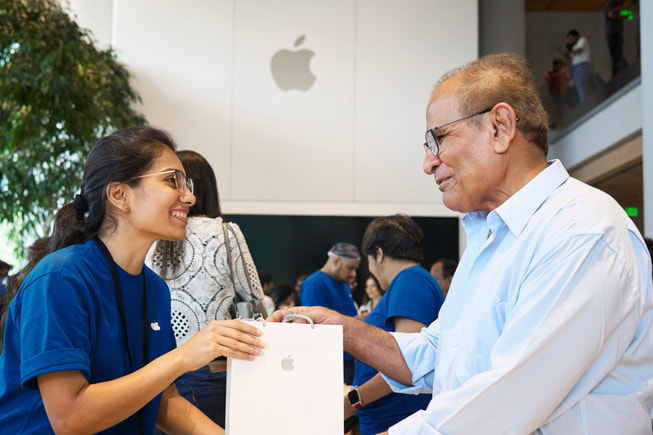 Un membre de l’équipe Apple aide un client avec son achat. 