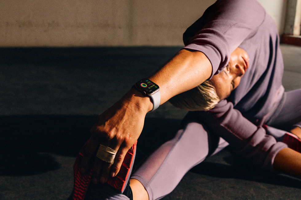 En person som har på seg Apple Watch Series 10, strekker ut i en yogalignende posisjon.