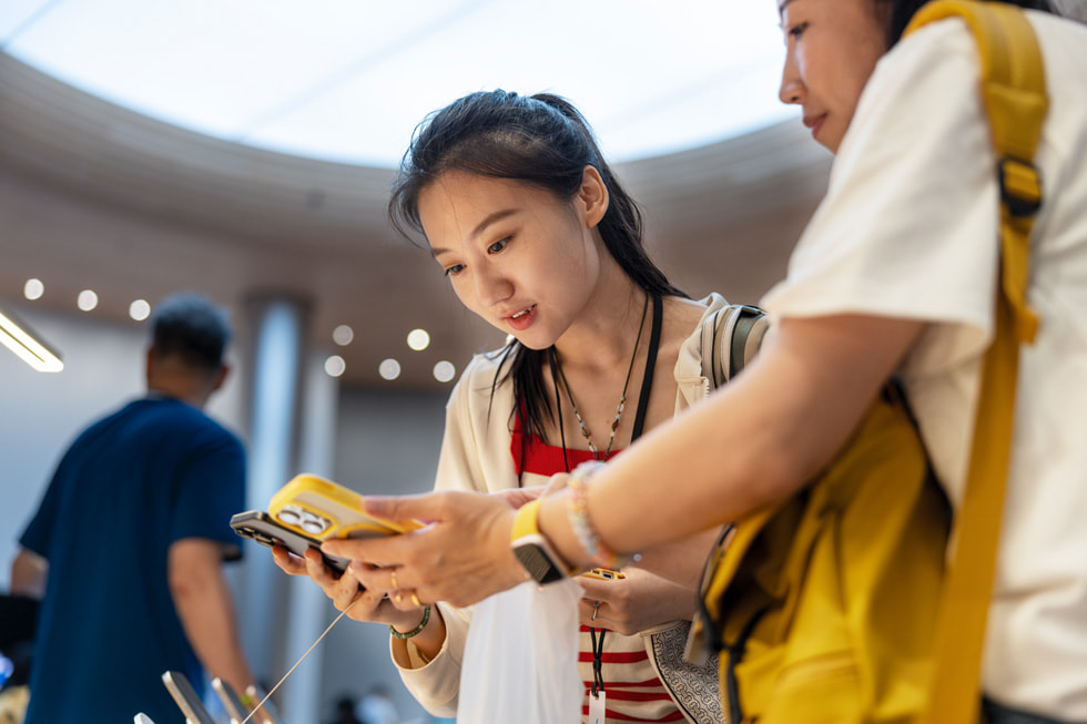 Two customers compare the new iPhone 16 Pro to their personal device.