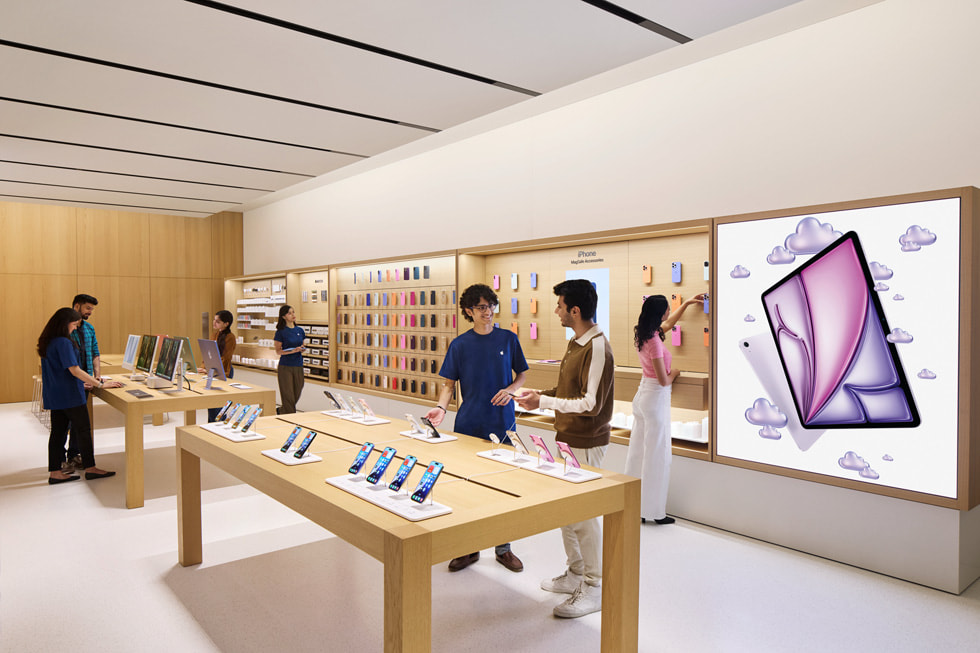 Imagen de Especialistas de Apple conversando con clientes en la tienda Apple Hebbal.
