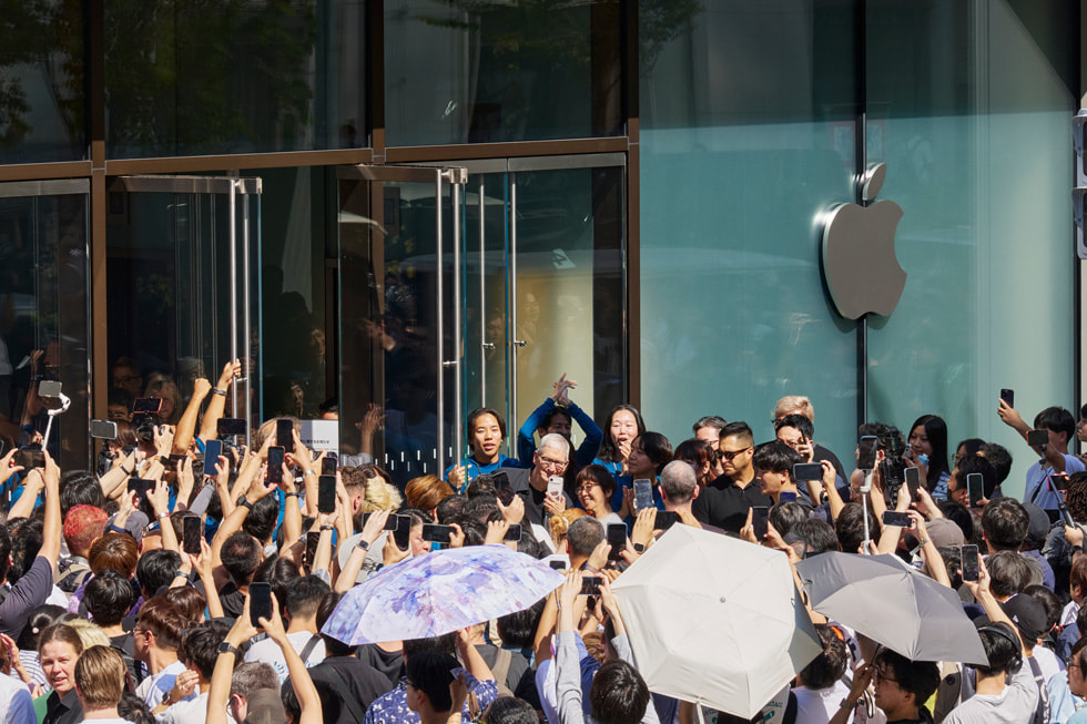 Tim Cook umgeben von einer Menschenmenge aus Kund:innen und Teammitgliedern vor Apple Ginza.