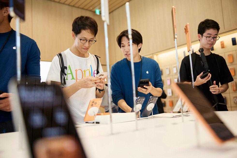 Ein Teammitglied mit einem Kunden, der ein iPhone 17 Pro in Silber in Apple Ginza in der Hand hält.