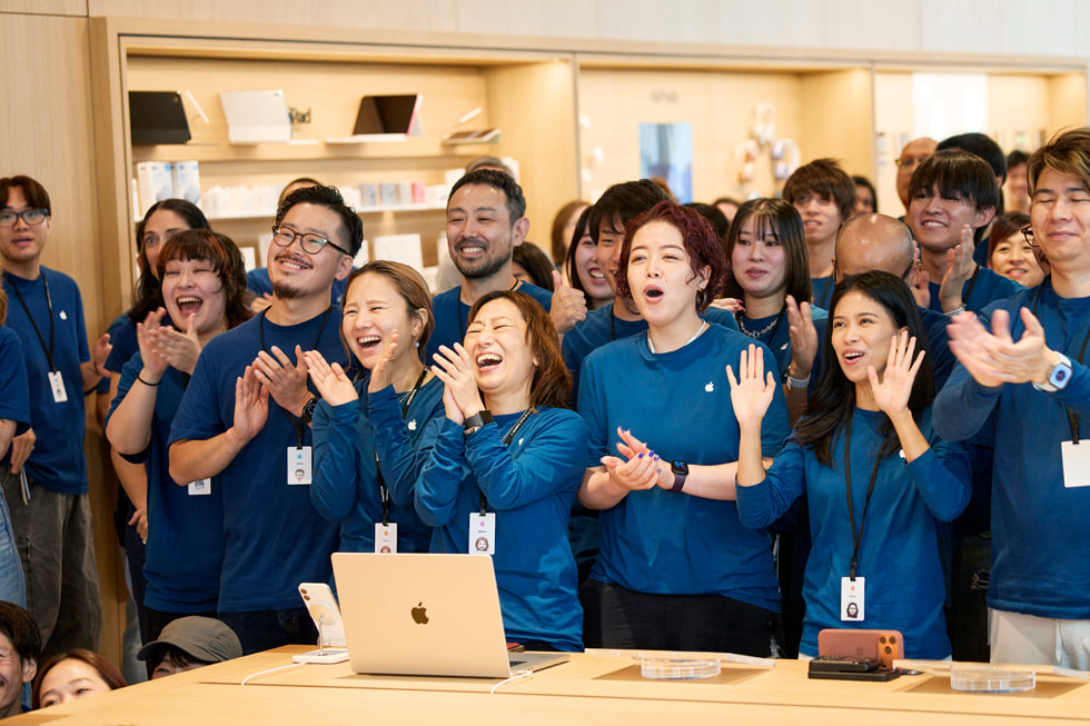 Teammitglieder klatschen im Inneren von Apple Ginza.