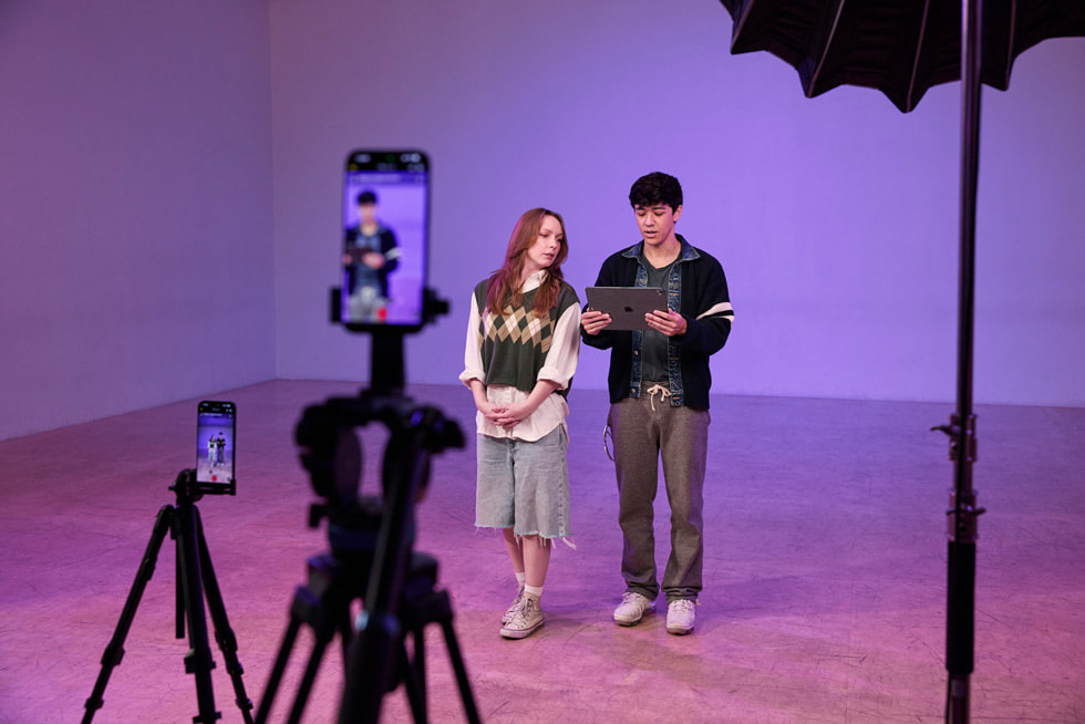 Dos dispositivos iPhone 17 Pro Max sobre trípodes graban a Kyle Hanagami y un bailarín en un estudio. Hanagami sostiene un iPad Pro.