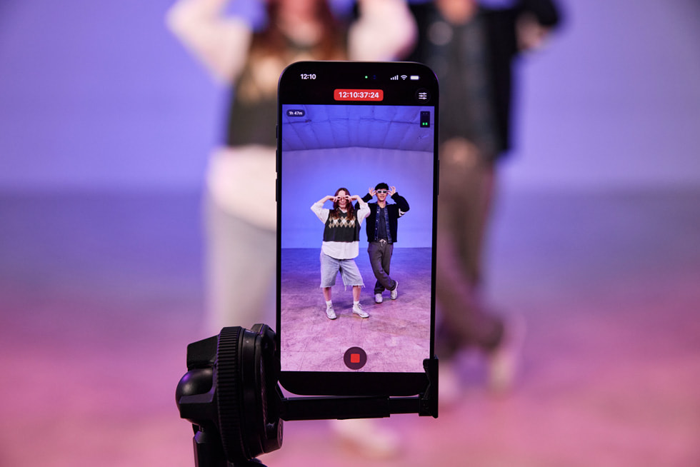 Primer plano de un iPhone 17 Pro Max sobre un trípode que muestra una grabación en vivo de Kyle Hanagami y un bailarín haciendo pasos de baile en un estudio.