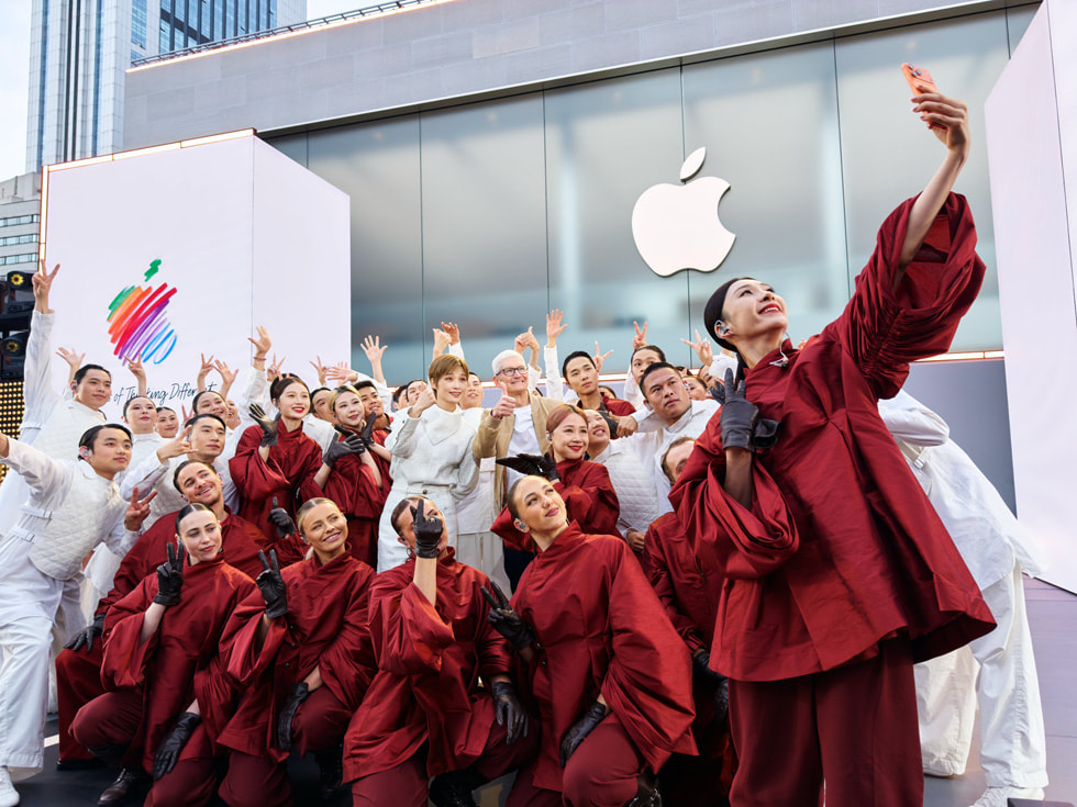 Tim Cook posa para una selfie con Chris Lee y sus bailarines vestidos con trajes blancos y rojos, en Apple Taikoo Li Chengdu, en China.