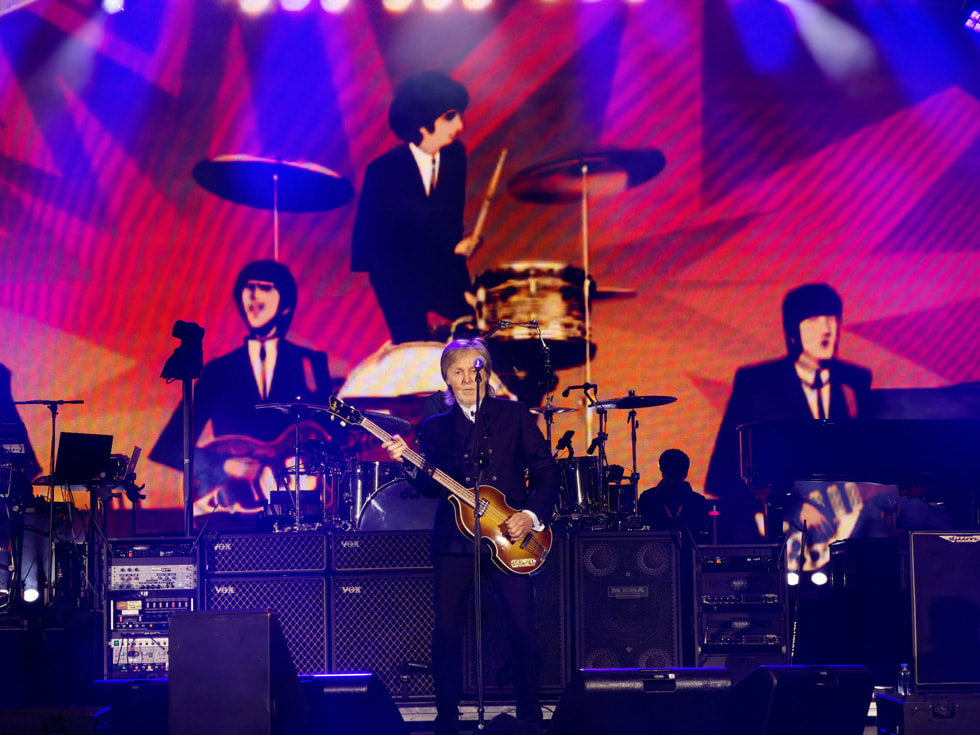 Paul McCartney presentándose en el escenario del Apple Park en Cupertino, delante de una pantalla con una animación de los miembros de los Beatles.
