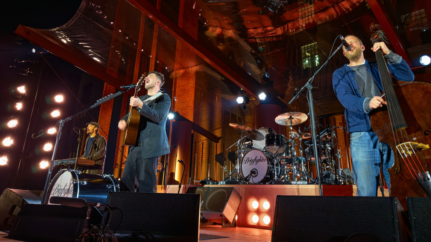 Integrantes de la banda Mumford & Sons tocan en un escenario fuera de Apple Battersea, en Londres.