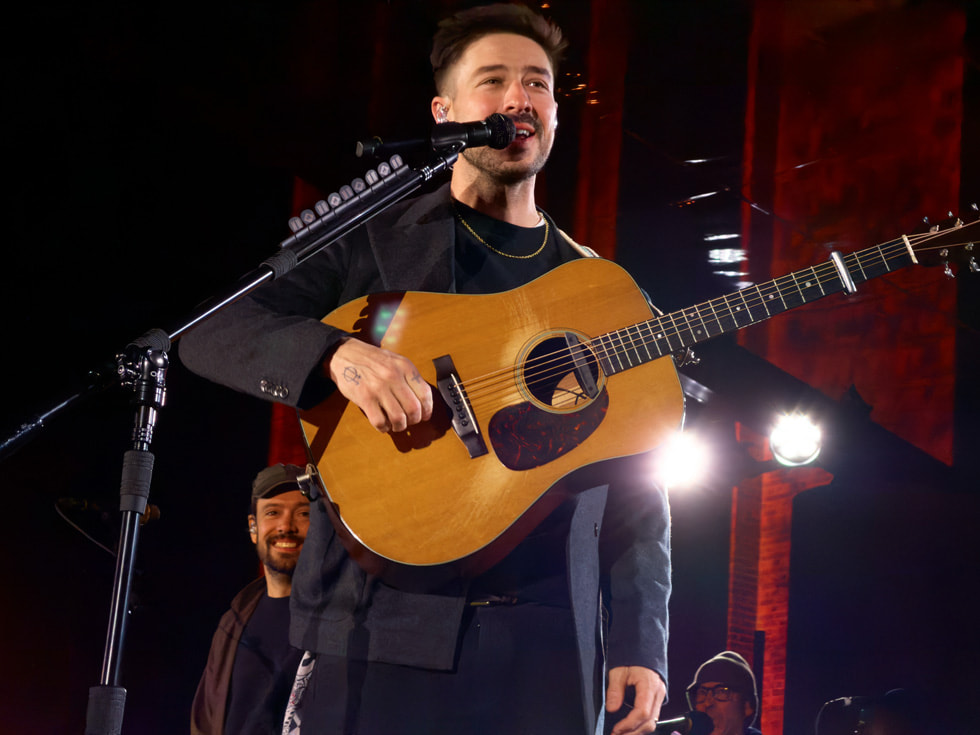 Imagen de Marcus Mumford en el micrófono y la guitarra en Apple Battersea, en Londres.