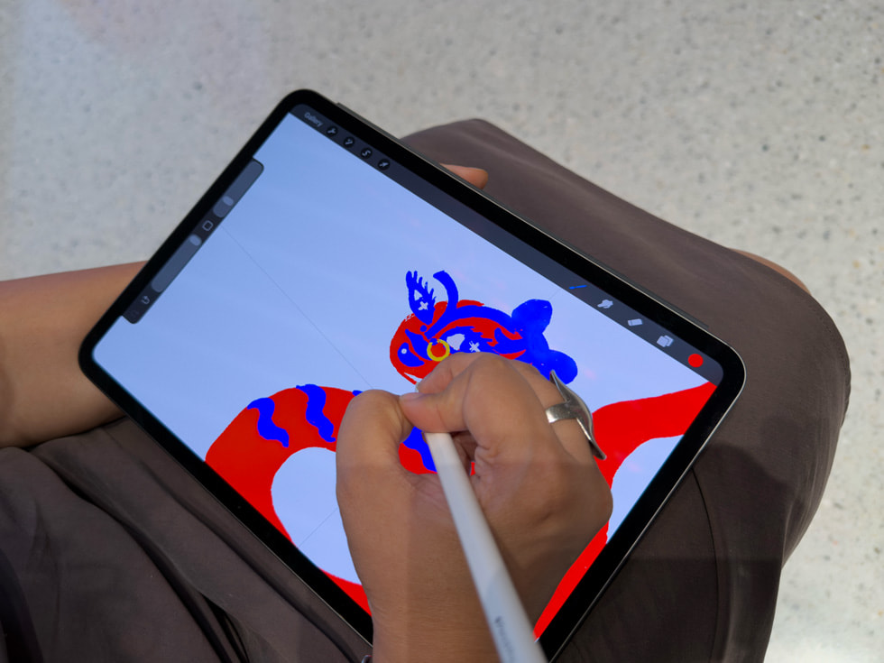Primer plano de Malhotra usando el Apple Pencil Pro y la app Procreate en el iPad Pro para sus ilustraciones.