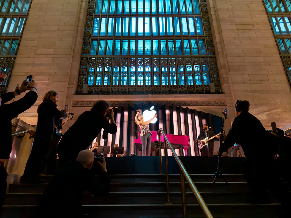 Foto panorámica de Alicia Keys cantando desde las escaleras de la tienda.
