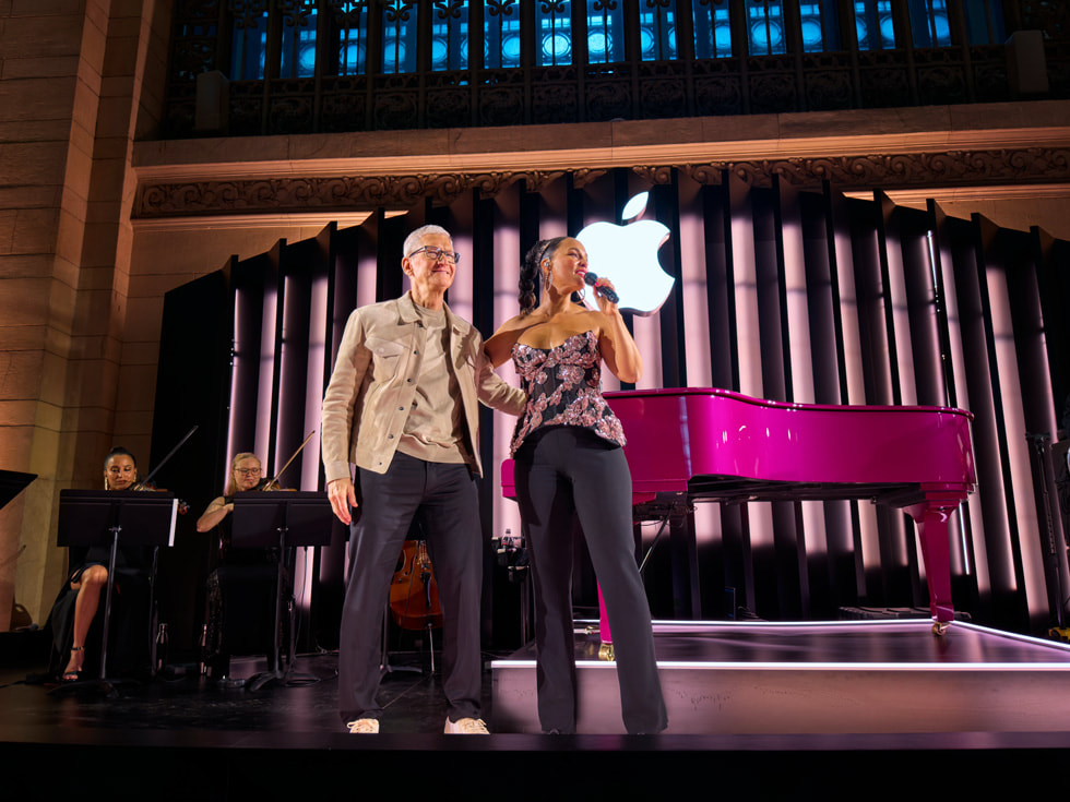 Tim Cook saluda de pie desde el escenario junto a Alicia Keys.