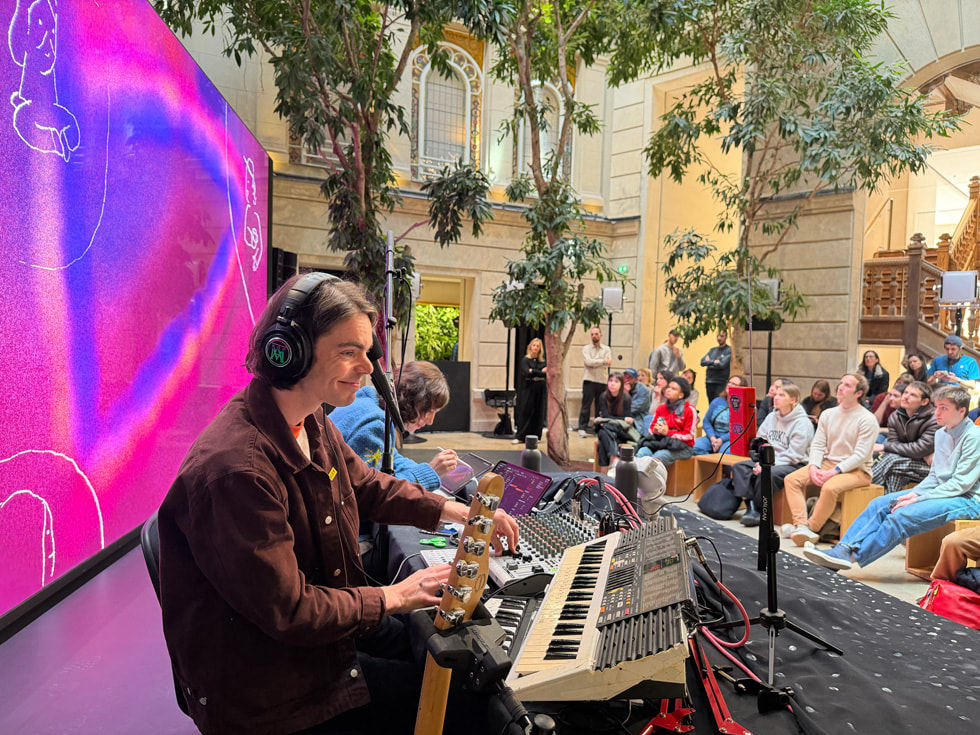 Pi Ja Ma usa  el iPad para ilustrar en vivo junto a SOPORI FM frente a una de las pantallas de Apple Champs-Élysées, París