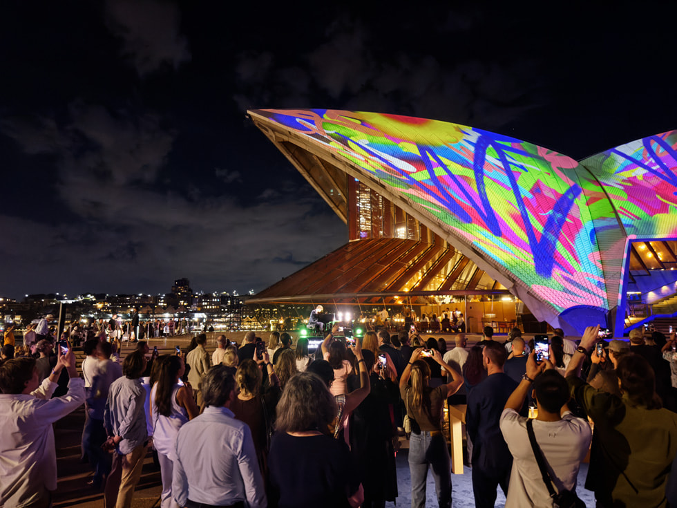Una multitud participa de la proyección de Apple en las bóvedas de Bennelong.