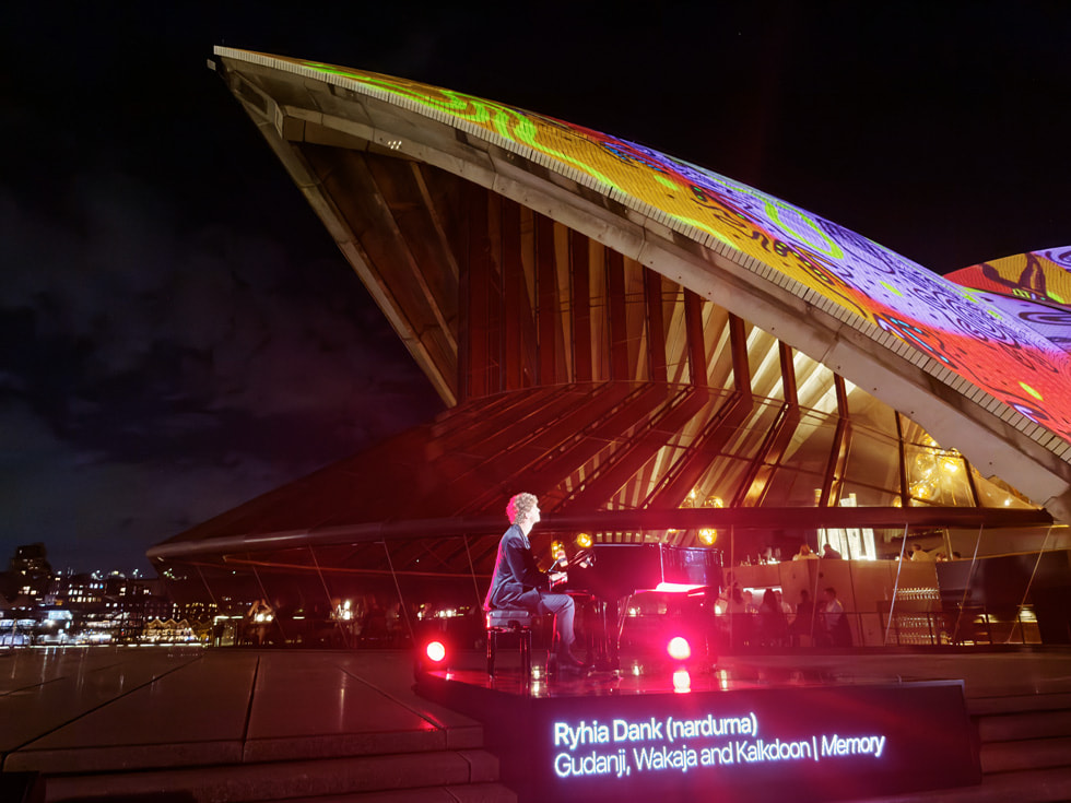Un pianista acompaña la proyección de Apple frente a las bóvedas de Bennelong.