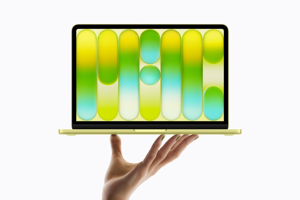 Una mano sostiene la nueva MacBook Neo en amarillo cítrico.