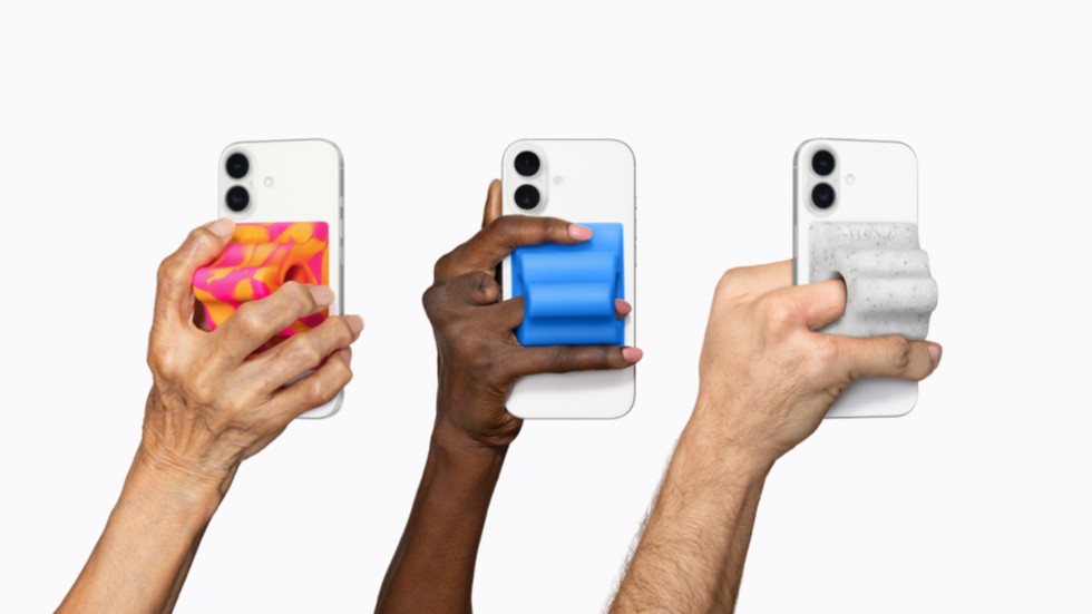 Tres manos sujetan dispositivos iPhone 17 Pro, cada uno equipado con un colorido accesorio adaptativo Grip & Stand de Hikawa.