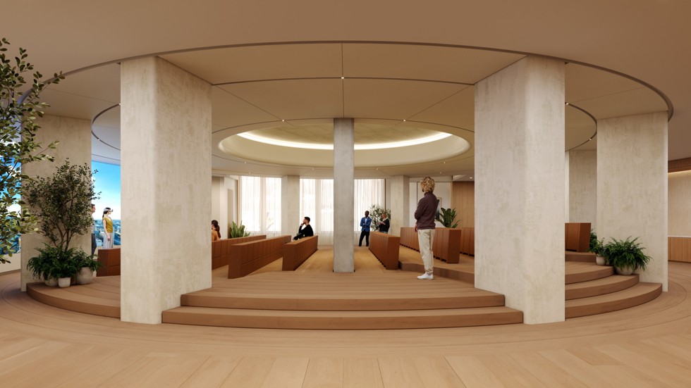 A large, circular auditorium with tiered wooden seating and a presentation area at the center.