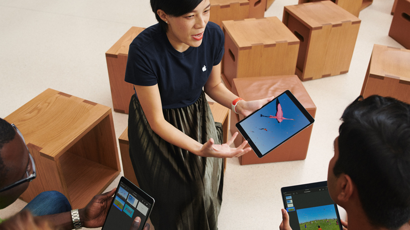 iPad kullanan bir Apple ekip üyesi ve iki müşteri.
