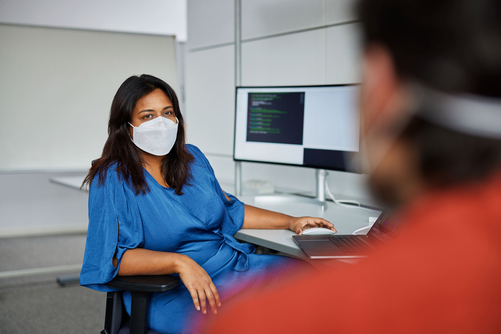Tano Gupta met een collega in een software-engineeringruimte in München.