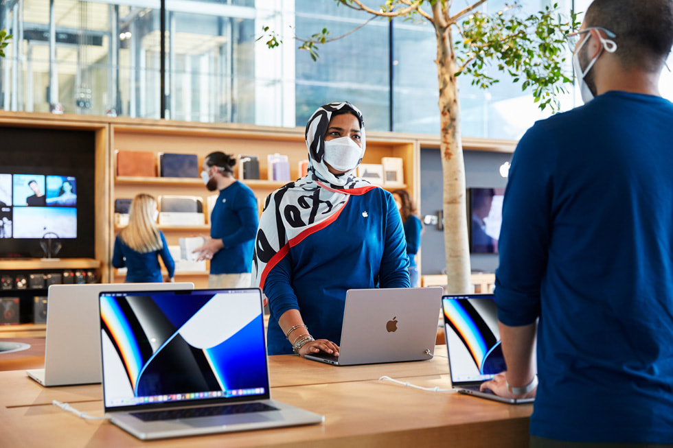 فريق متجر Apple بجزيرة المارية ينصبون طاولة MacBook Pro داخل المتجر.