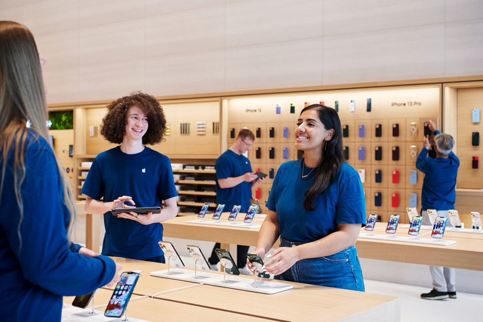 Drie medewerkers staan afgebeeld in Apple Brompton Road in Londen.