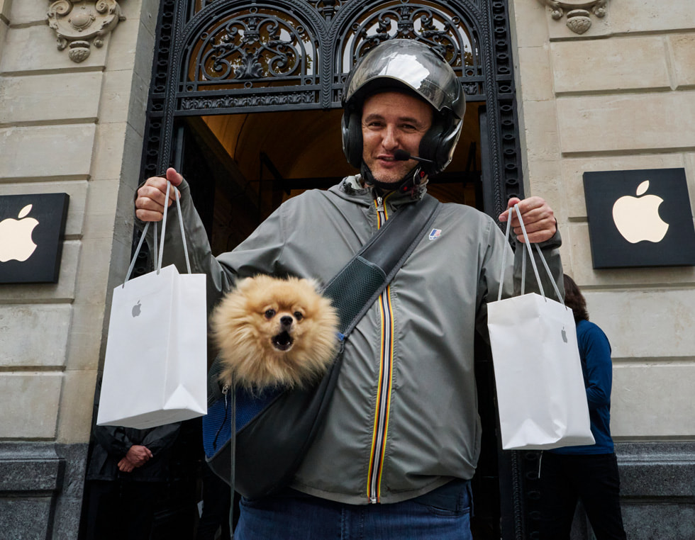 En kund undersöker en visningsmodell ur iPhone 14-serien på Apple Champs-Élysées.